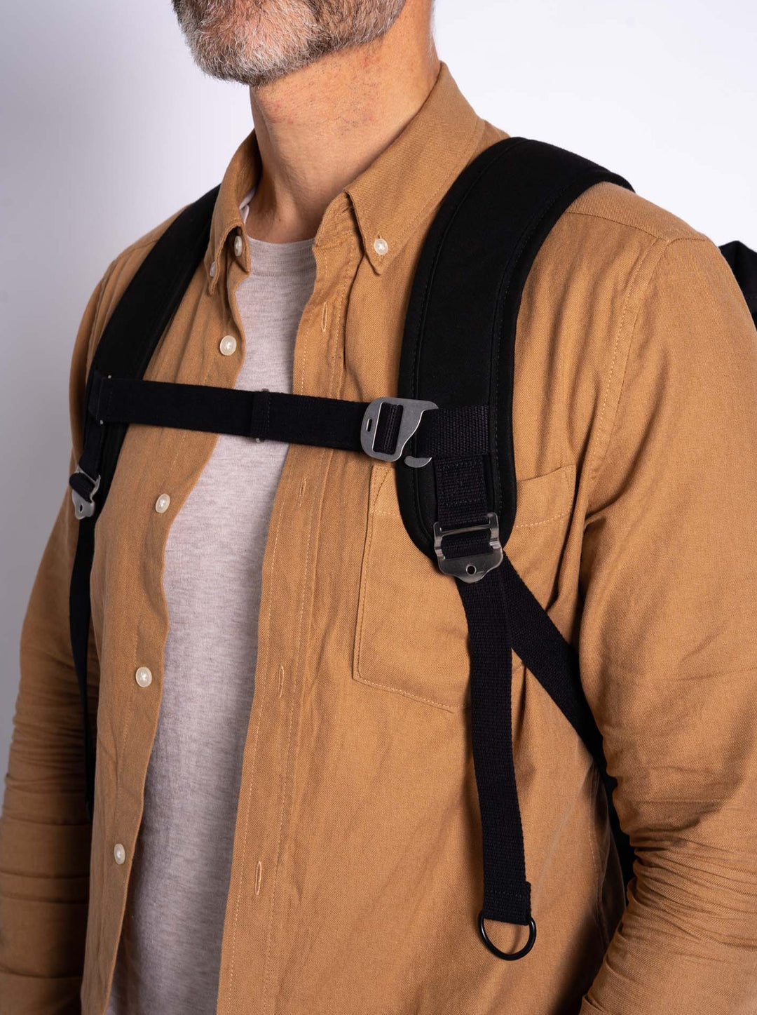 Picture of man wearing a Trakke Black Backpack Chest Strap with G-hook and cotton webbing. Extendable design.